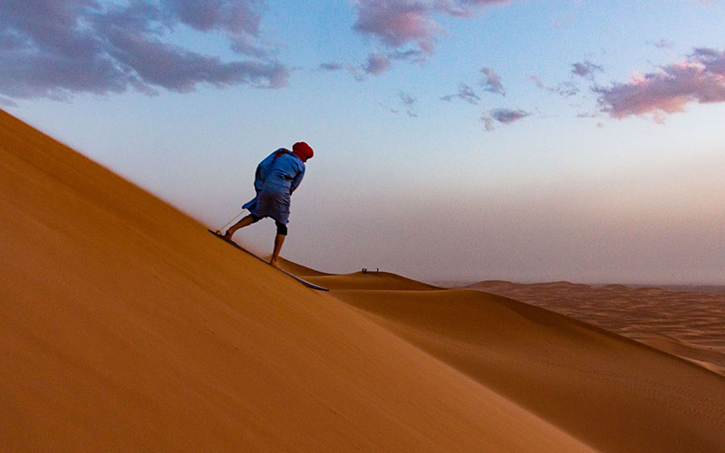 Sandboarding at sunset in the Sahara, Merzouga, Morocco